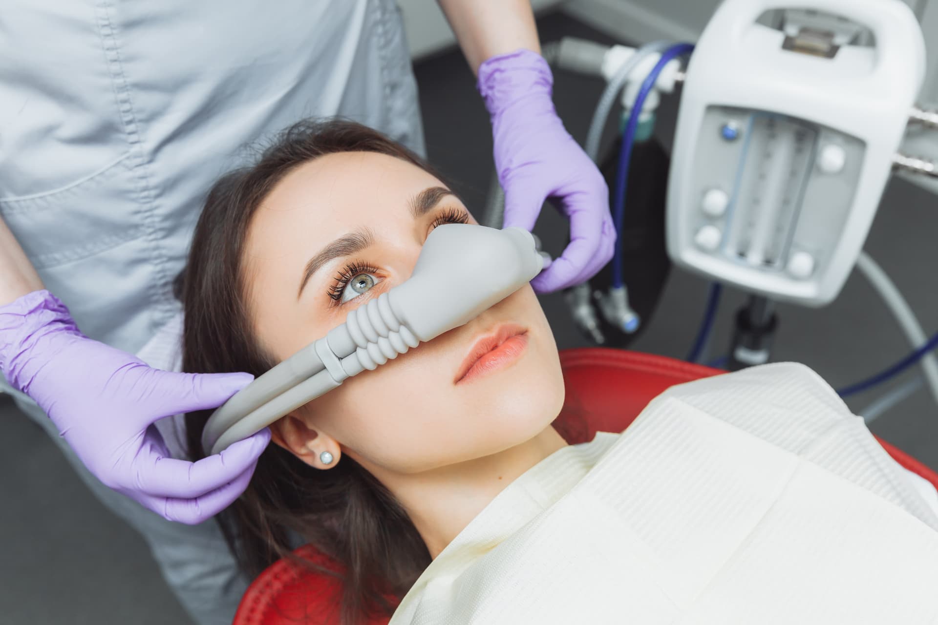 A calm patient relaxing in a dental chair with a blanket during sedation dentistry.